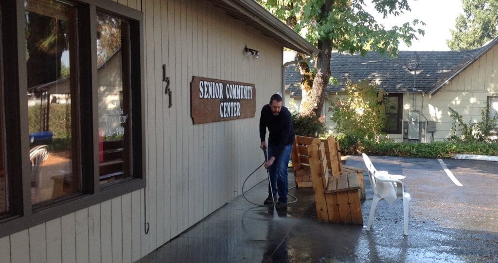 Mike Upston power washing the area in front of the building.